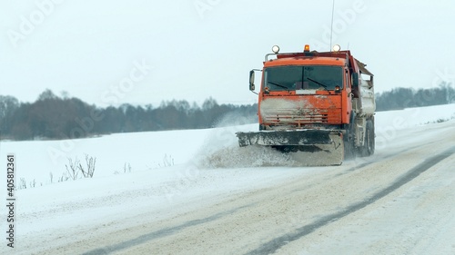 Winter. A special vehicle clears the road from snow.