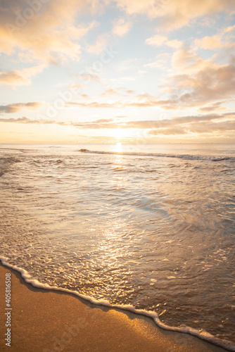 Wonderful golden sunset on the beach and calm sea.