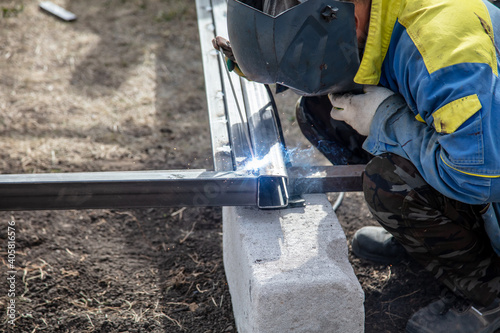 A worker welds metal at a construction site. Technology
