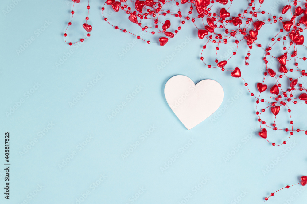 Valentine's Day background. One white heart with beads with hearts on pastel blue colors. Valentine's Day concept. Flat lay.