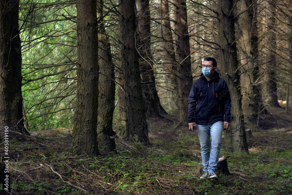 young man walks through the woods during the new normal young man walks through the woods during the new normal