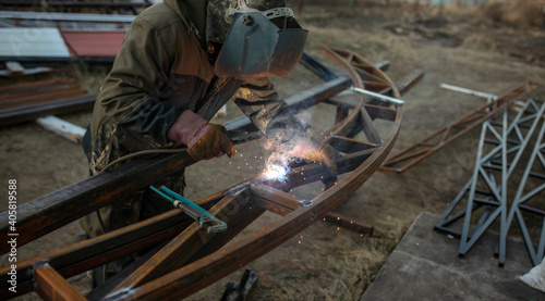 A worker welds metal for a canopy.