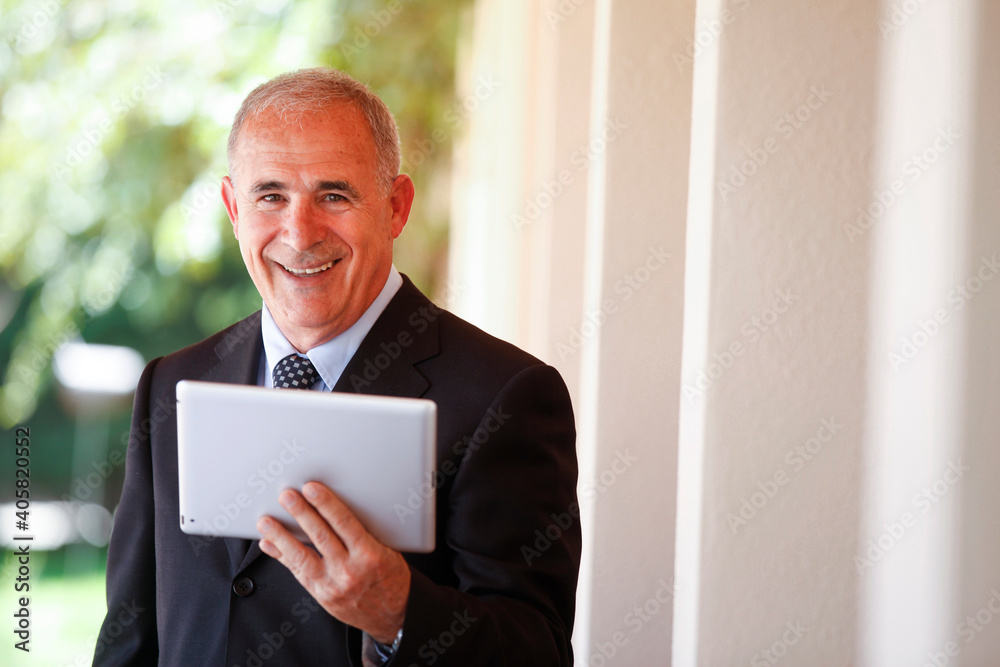 manager senior lavora tine in mano un tablet e sorride felice manager senior lavora tine in mano un tablet e sorride felice