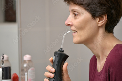 Portrait Of A Young Womanand and Professional Oral Irrigator photo