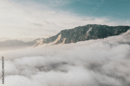 Aerial view above the cliffs and mountains meeting the sky and clouds. Picturesque landscape. Majestic nature in Turkey