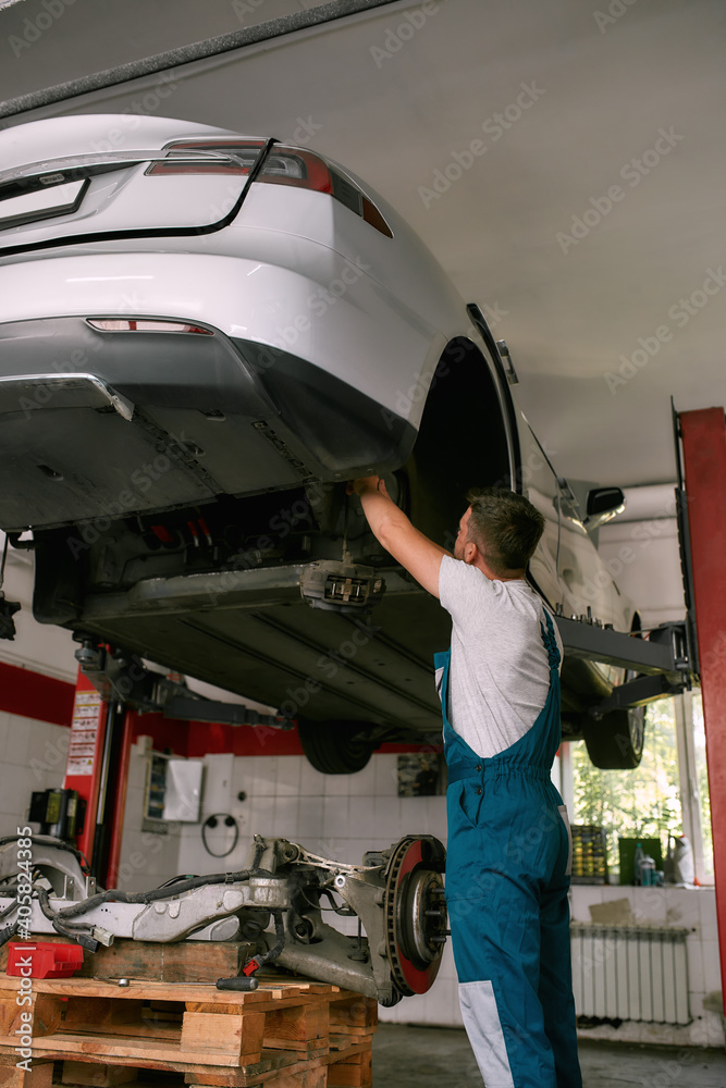Mechanic repairing auto on car service station