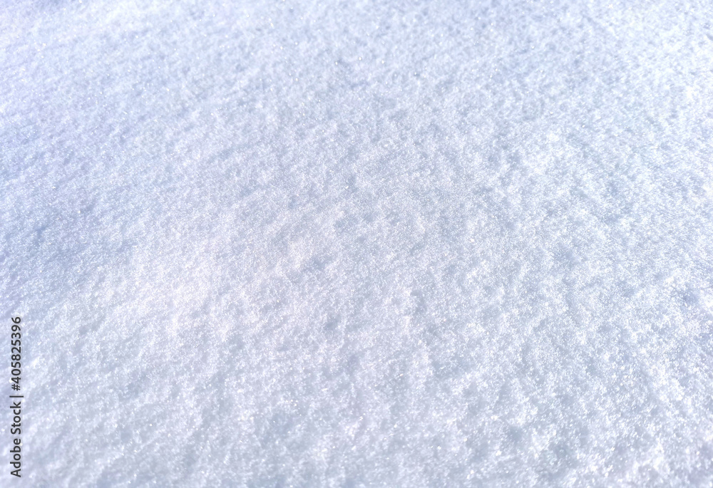 Clean snow surface in sun light, blue white texture with visible snowflakes. Natural winter frozen background