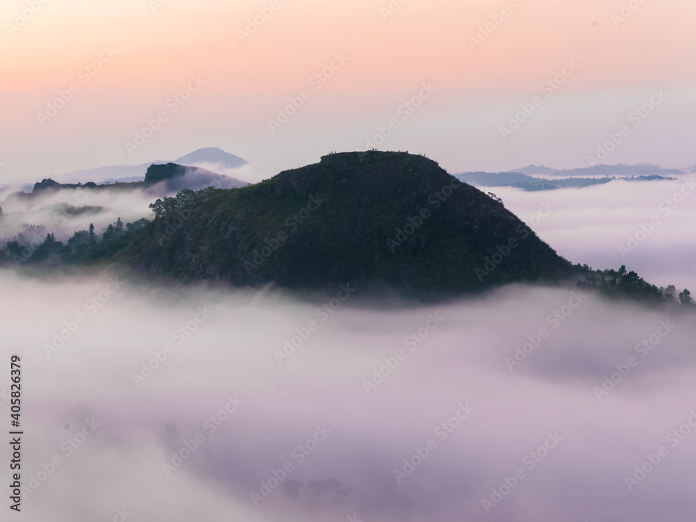 view of scenic green mountain hills in manjapaara , amabalavayal wayanad covered in early morning fog and twilight.