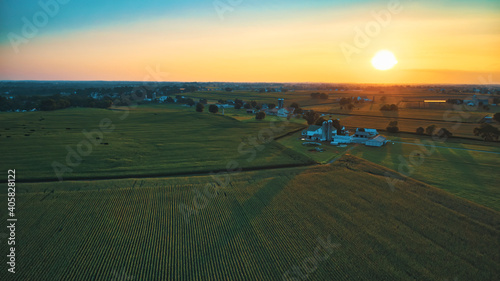 Aerial View of Multiple Farms and Pastures with Field of Corn Grows on Them at Sunset on a Beautiful Summer Day
