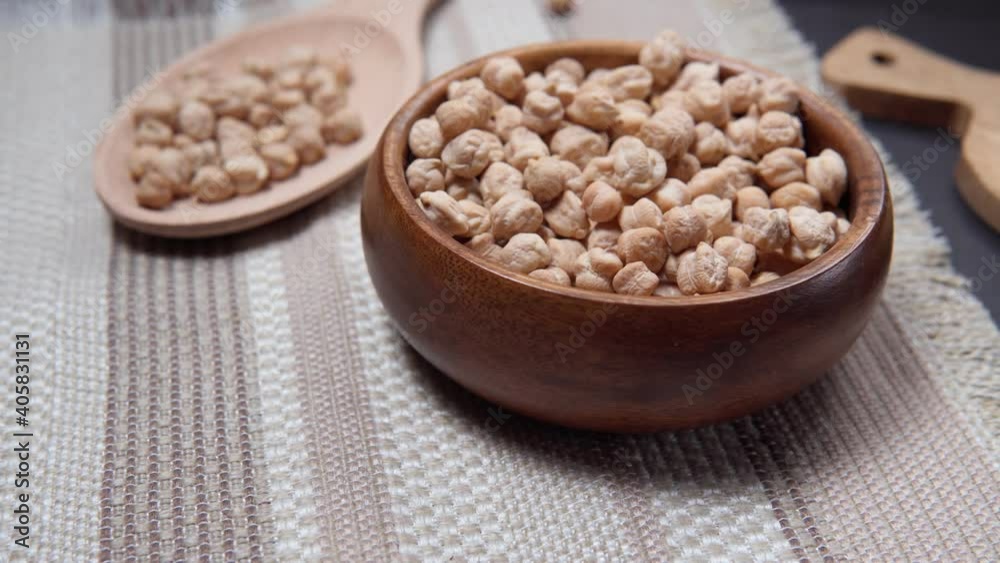 Bowl with organic dry chickpeas on an stone table pours into a bowl Bowl with organic dry chickpeas on an stone table pours into a bowl