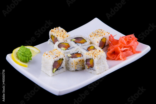 Kani avocado maki - Rolls with crab meat, avocado and sesame on a white plate on black background