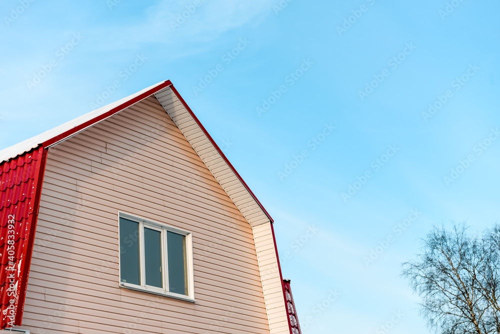 The roof of the house against the blue sky - winter view The roof of the house against the blue sky - winter view