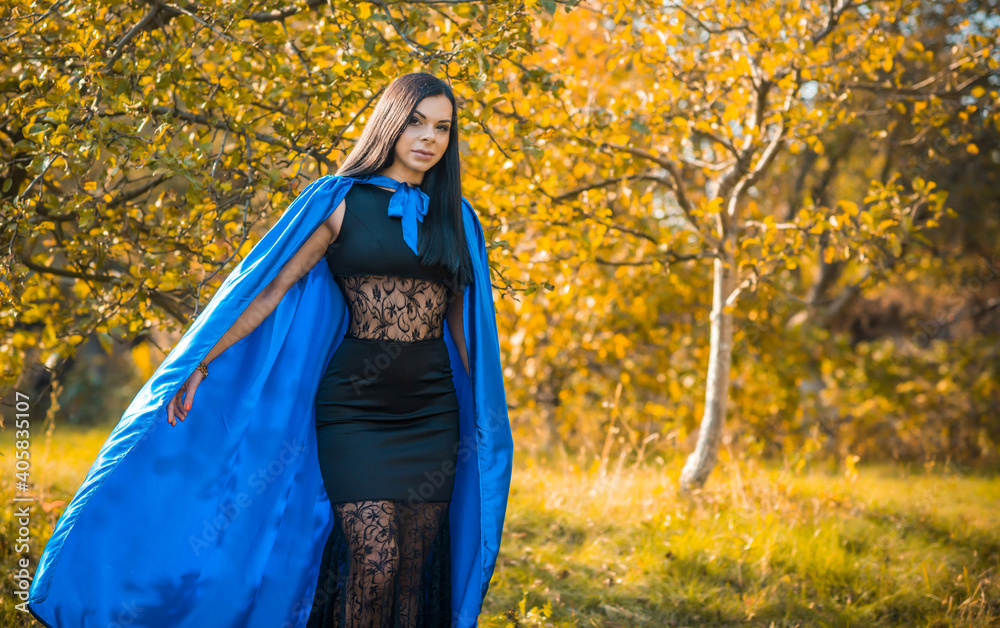 Woman in blue cloak and black dress, costumes for ladies. Girl in glamourous mascaraed dress Woman in blue cloak and black dress, costumes for ladies. Girl in glamourous mascaraed dress
