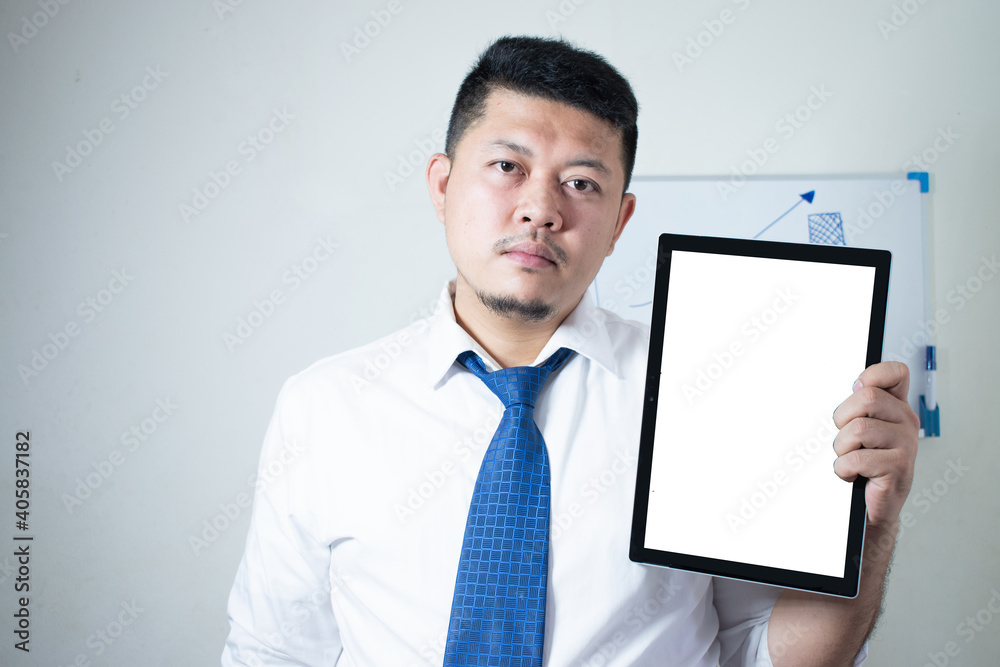Young Asian businessman Wear a white shirt Tie a blue tie using his tablet Young Asian businessman Wear a white shirt Tie a blue tie using his tablet