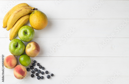 Group of fruits over white wooden table with copy space