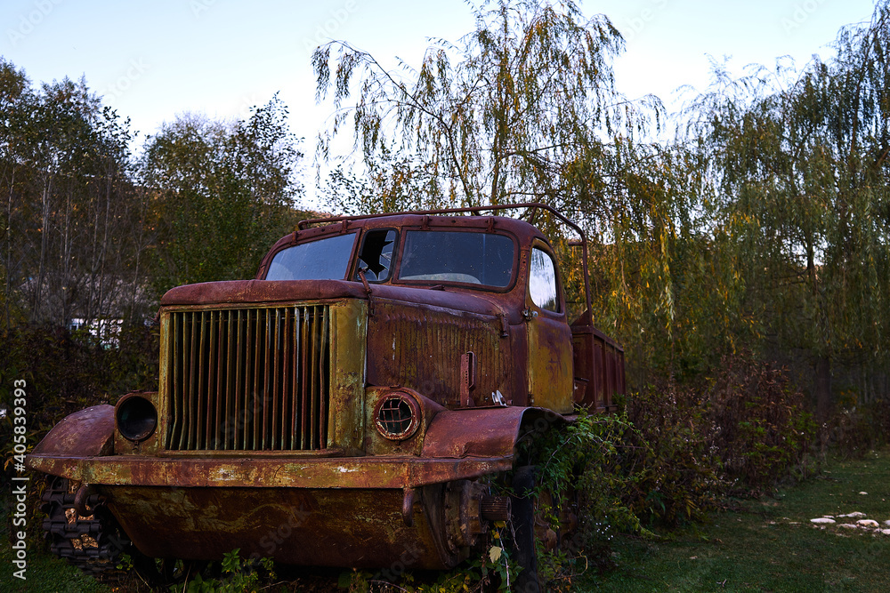 The wreckage of an old tracked all-terrain vehicle. Autumn landscape.