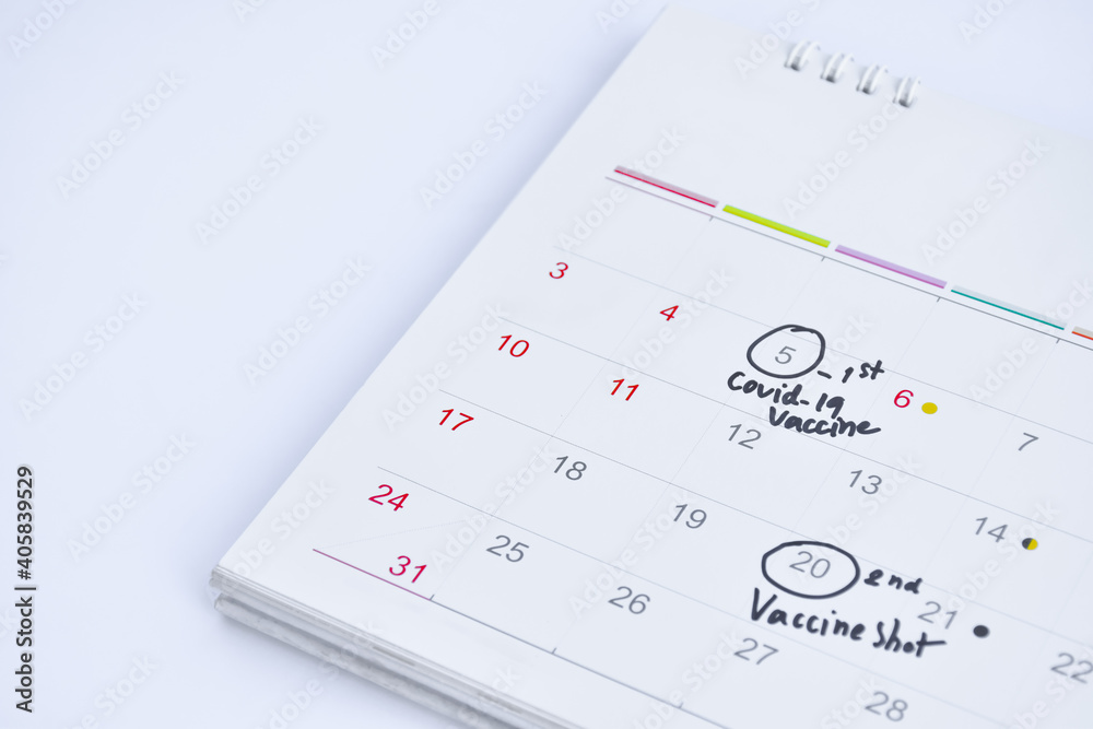 Desk white calendar with covid-19 vaccine appointment around the number. concept for doctor appointment to get covid-19 vaccine. Desk white calendar with covid-19 vaccine appointment around the number. concept for doctor appointment to get covid-19 vaccine.