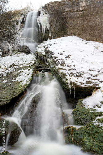 Waterfall on cold snowy winter day