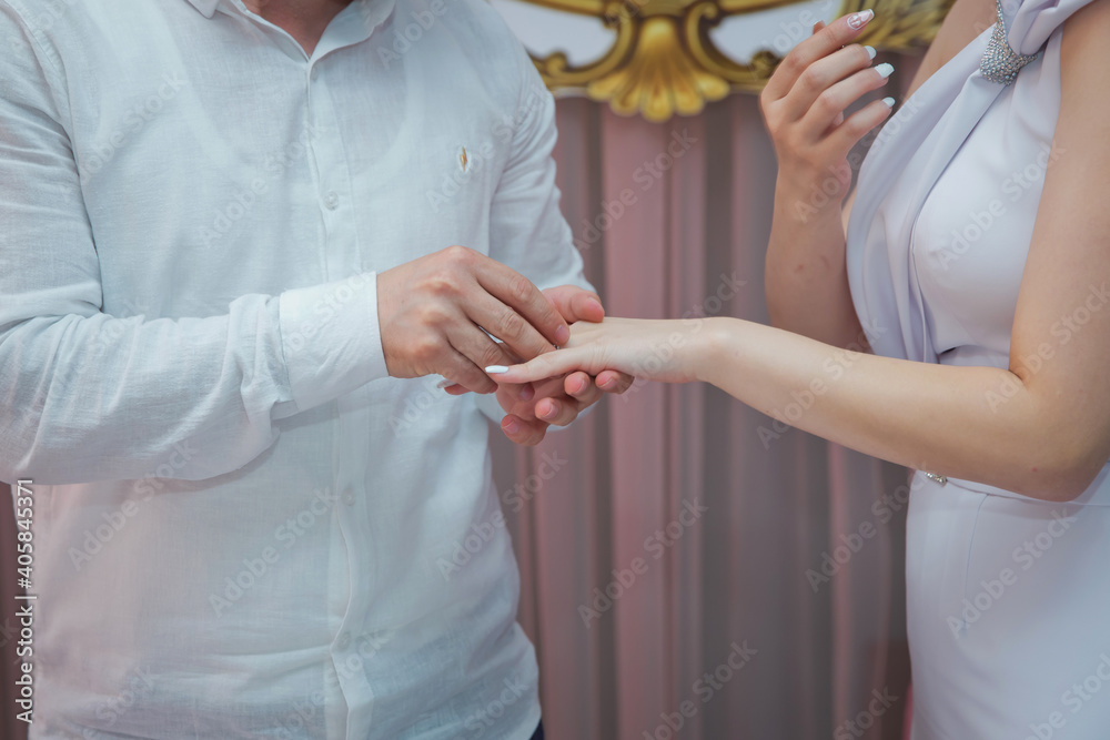 A man is giving a ring to his girlfriend and wearing in on her finger. Young woman caught because her boyfriend gives an henna ring at breakfast.