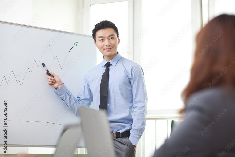 Portrait of young businessman standing in front of the whiteboard Portrait of young businessman standing in front of the whiteboard