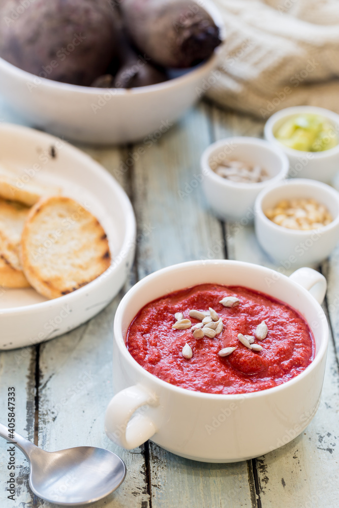 Red Beetroot mashed soup with cream and sunflower seeds in a white bowl. Red Beetroot mashed soup with cream and sunflower seeds in a white bowl.