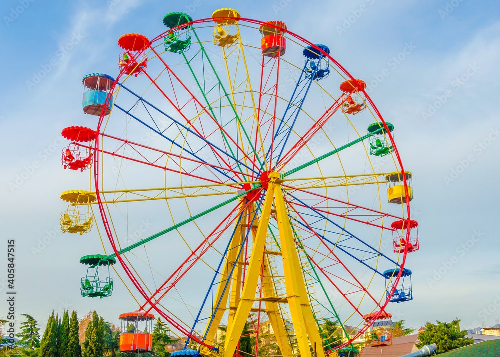 Ferris wheel in the park against the blue sky.