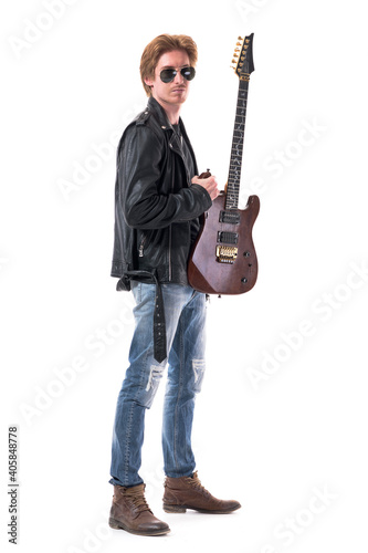 Handsome young rock music guitarist posing and holding electric guitar looking at camera. Full body isolated on white background. 