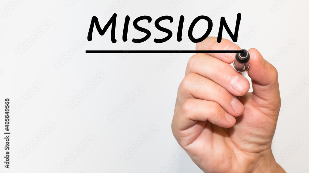 the hand writes text MISSION with a marker on a white background. business concept the hand writes text MISSION with a marker on a white background. business concept