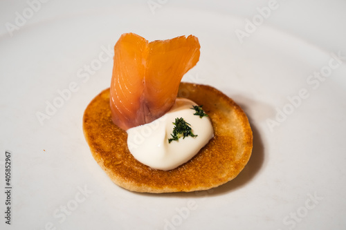 Salmon Blini garnished with Sour Cream on a White Plate photo