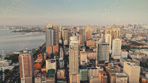 Tropic city cityscape with modern buildings and skyscrapers aerial. Philippines metropolis town of Manila at ocean coast. Beautiful streets and roads. Cinematic scenery at summer sunny day