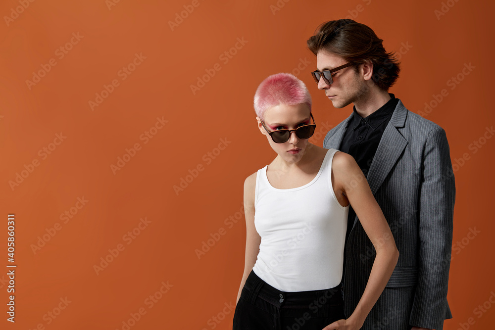 Obraz premium Stylish young hipsters woman and man in sunglasses, posing together, over brown background. Profile portrait.