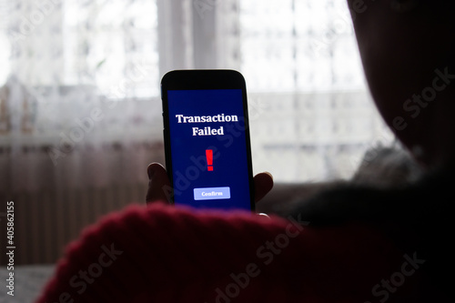 Transaction failed notification in a mobile phone screen. Close up of woman, girl using holding her mobile phone. photo