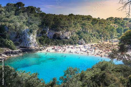 People on the beach enjoying the summer holiday on the coast of Mallorca island, in Cala Llombards in Spain
