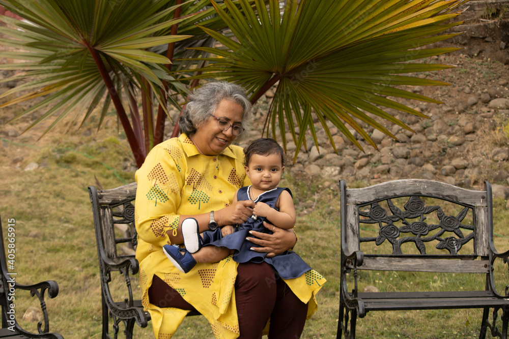 Happy moments with grandma, indian or asian senior lady spending quality time with her grand daughter in garden.