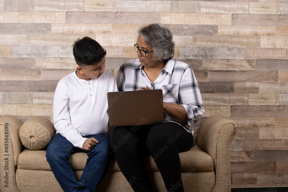 Happy moments with grandma, indian or asian senior lady spending quality time with her grand son using laptop
