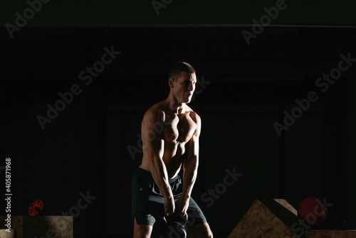 High contrast photo of a healthy fitness guy doing workout using a kettlebell © qunica.com