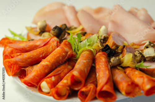 A cold plate prepared for the party with sliced chorizo, ham and sausages
