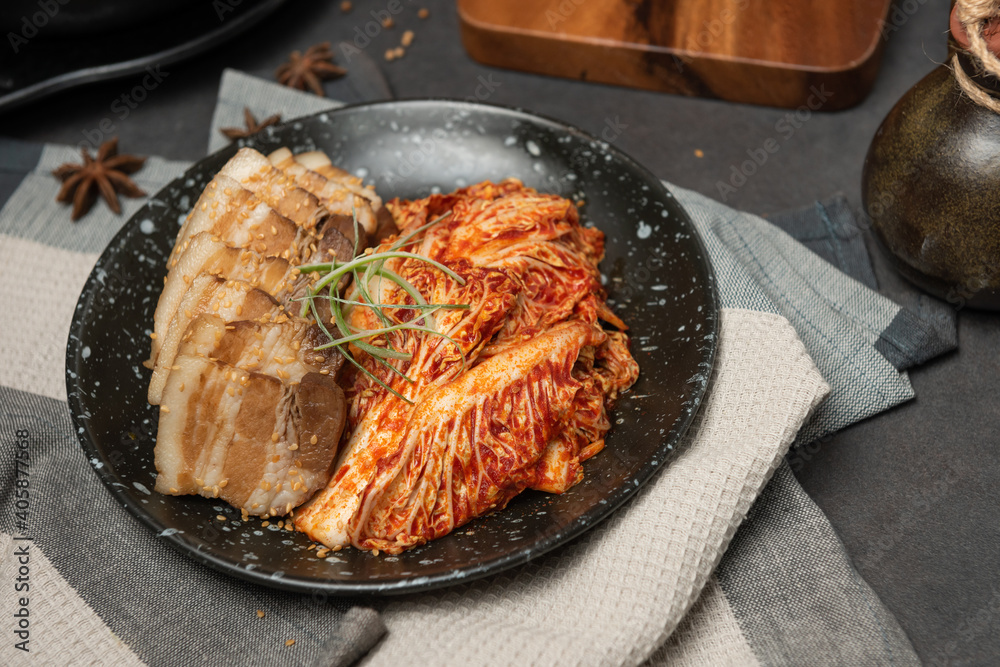 Korean Boiled Pork with preparing cabbage kimchi in black dish. Korean traditional cuisine. Fermented food. Korean Boiled Pork with preparing cabbage kimchi in black dish. Korean traditional cuisine. Fermented food.