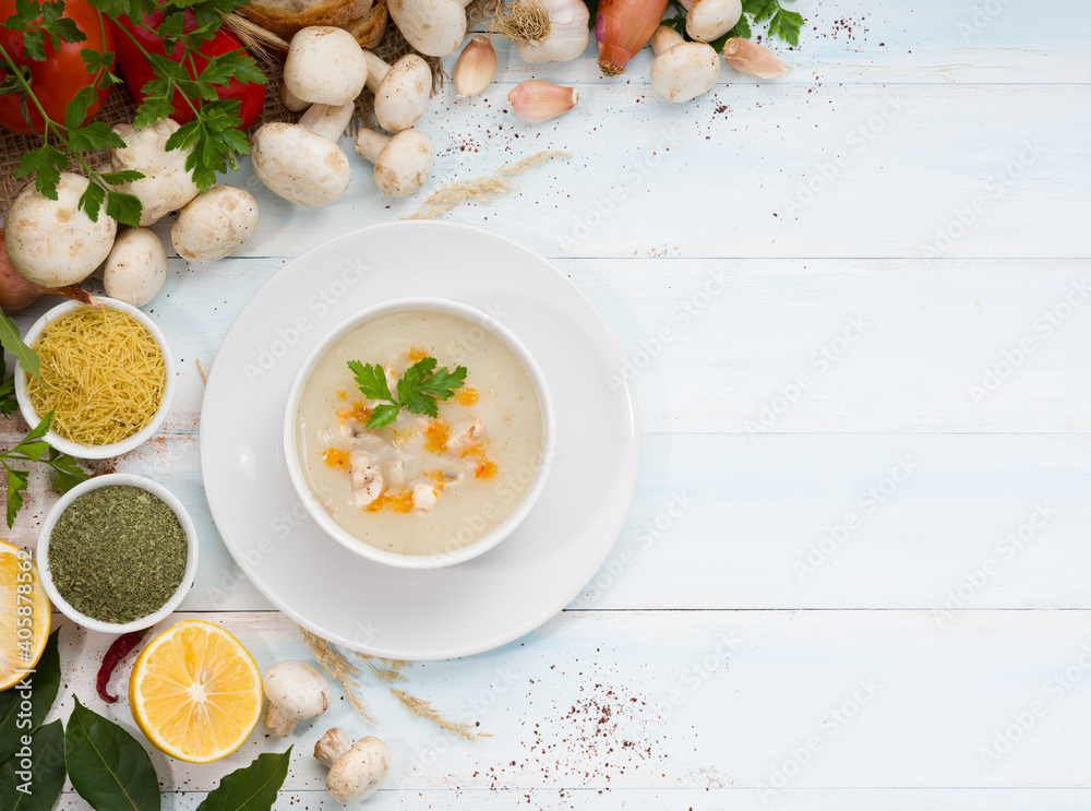 Creamy mushroom soup with colorful vegetables on white old table