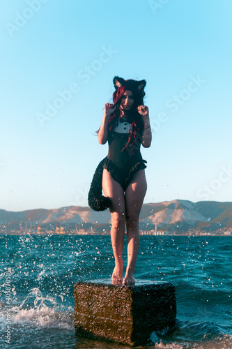 girl with cat tail and ears on the beach