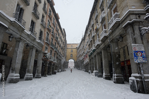 View of the access doors of the historic Plaza Mayor of Madrid covered with snow under a heavy snowfall. © ahau1969