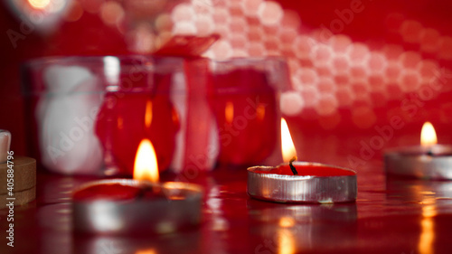 Candles for valentines day  table with festive red background.
