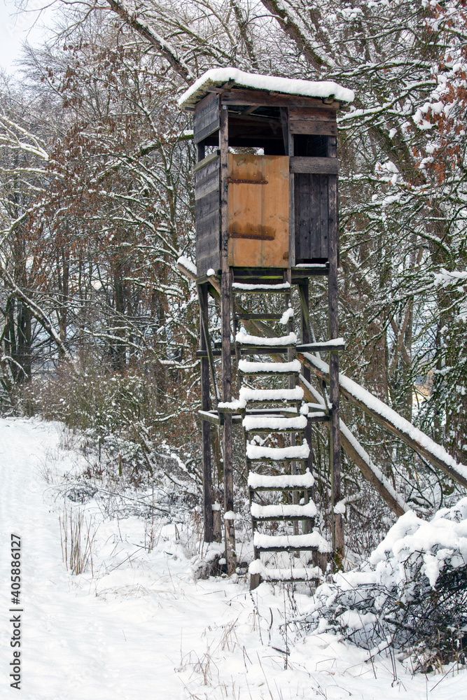 A deerhunter's perch with snow-covered ladder in a forested area in Bavaria during winter A deerhunter's perch with snow-covered ladder in a forested area in Bavaria during winter