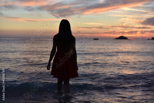 Valokuva woman in dress walking away to sea on sunset