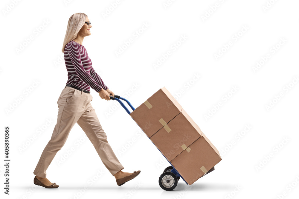 Woman walking and pushing a hand-truck with a pile of boxes Woman walking and pushing a hand-truck with a pile of boxes
