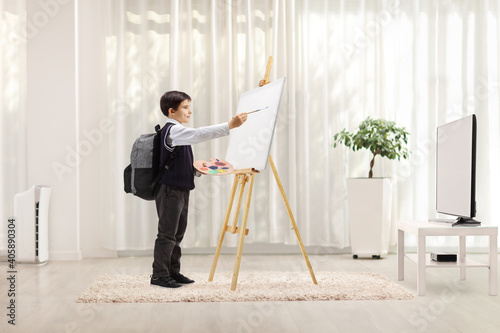 Schoolboy using an easel and painting on a canvas © Ljupco Smokovski