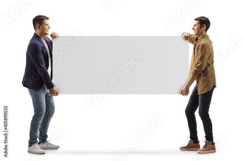 Photos Full length profile shot of two casual men carrying a blank panel