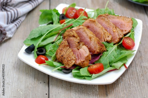 Fresh vegetable salad from tomato,lettuce, black olive with pork fillet