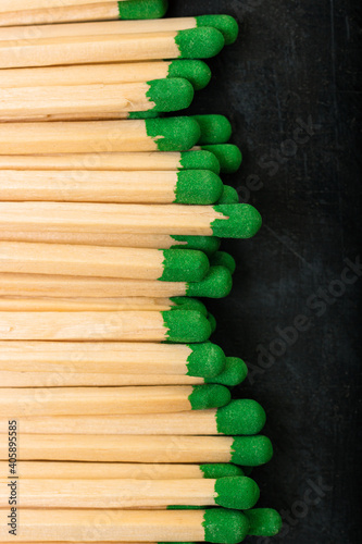 Long wooden matches with green gray laid out in a row