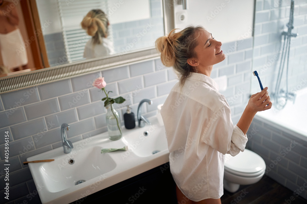 Young handsome girl enjoying a beautiful morning in the bathroom. Hygiene, bathroom, morning Young handsome girl enjoying a beautiful morning in the bathroom. Hygiene, bathroom, morning